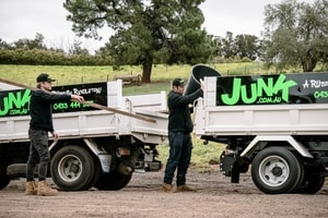 2 guys loading rubbish to a truck